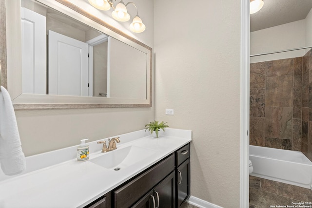 full bathroom featuring vanity, baseboards,  shower combination, toilet, and a textured wall