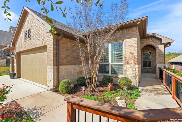 view of front of home with fence, concrete driveway, an attached garage, a shingled roof, and brick siding