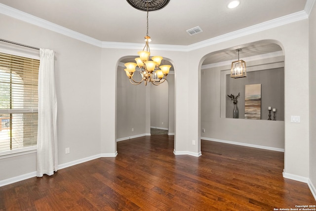 unfurnished room with hardwood / wood-style flooring, arched walkways, visible vents, and baseboards