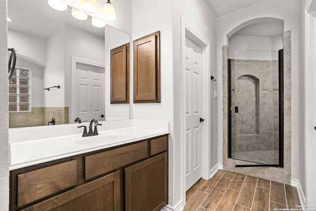 bathroom with vanity, a shower stall, and wood tiled floor