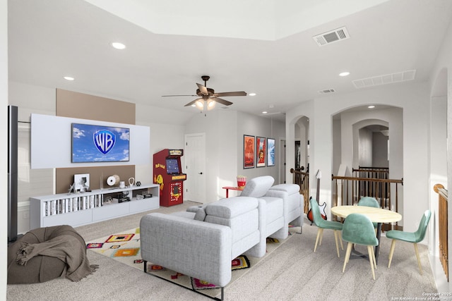 living area featuring arched walkways, visible vents, carpet flooring, and recessed lighting