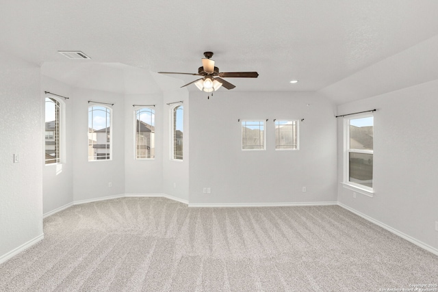 empty room with a ceiling fan, light colored carpet, visible vents, and baseboards