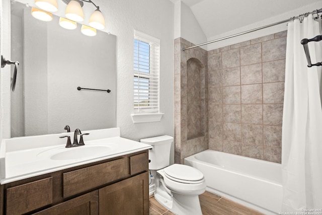 bathroom featuring wood finish floors, shower / bath combo with shower curtain, toilet, vaulted ceiling, and vanity