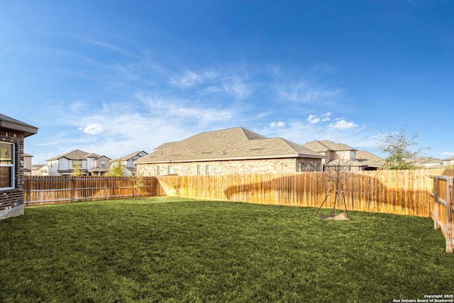 view of yard featuring a residential view and a fenced backyard