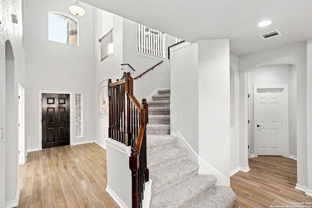 foyer with baseboards, visible vents, recessed lighting, arched walkways, and light wood-type flooring