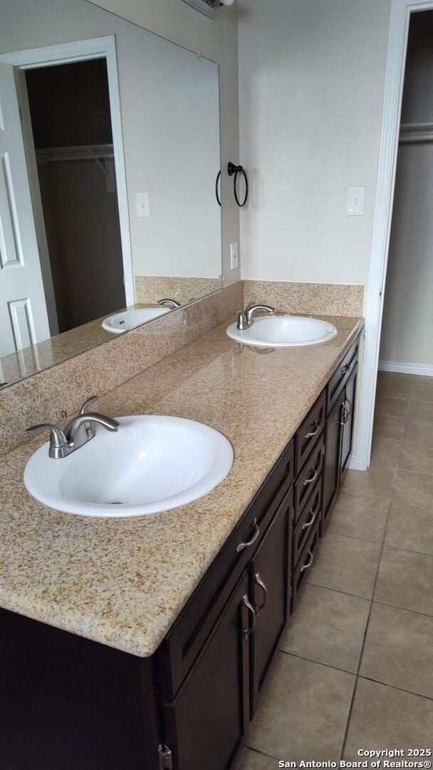 bathroom with tile patterned flooring, double vanity, and a sink