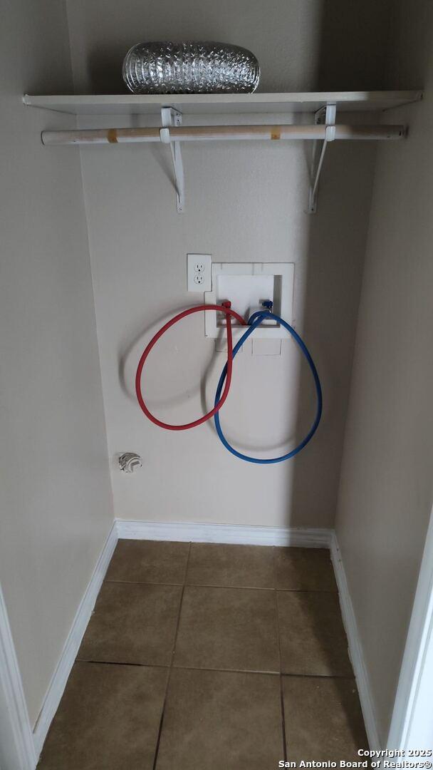 laundry area with baseboards, washer hookup, laundry area, and tile patterned flooring