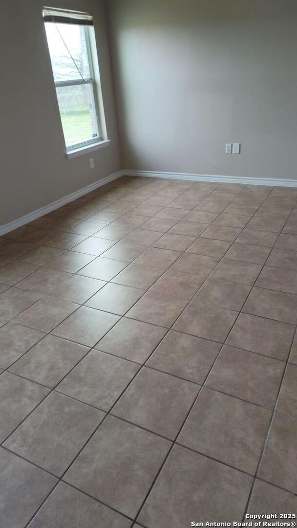 unfurnished room with baseboards