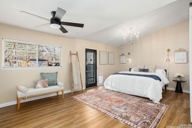 bedroom with vaulted ceiling, baseboards, and wood finished floors