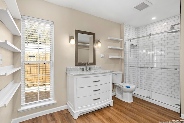 full bathroom with visible vents, toilet, wood finished floors, and a shower stall