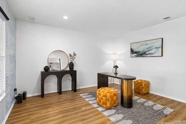 living area with recessed lighting, visible vents, baseboards, and wood finished floors