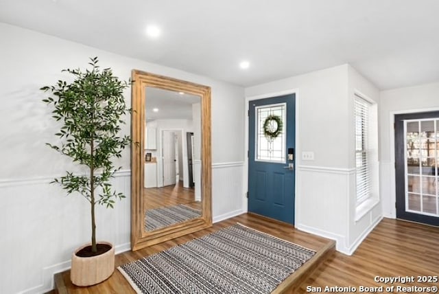 entryway featuring recessed lighting, wood finished floors, and wainscoting