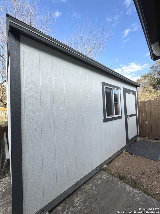 view of side of property featuring an outdoor structure and fence