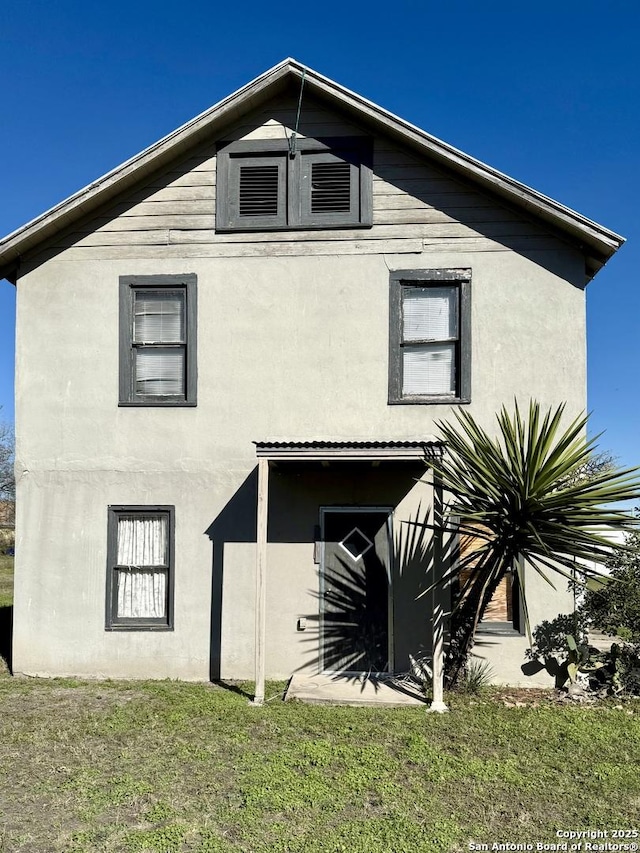 exterior space with a yard and stucco siding