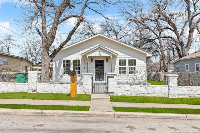 bungalow-style home with a fenced front yard and a gate