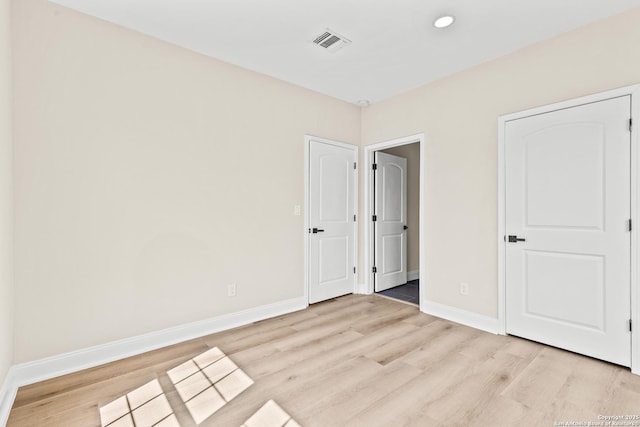 unfurnished bedroom featuring visible vents, light wood-type flooring, and baseboards