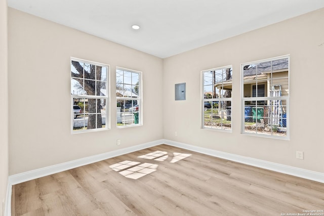 empty room with a wealth of natural light, baseboards, and wood finished floors