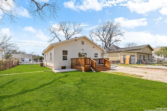 back of property featuring a deck, a yard, and fence