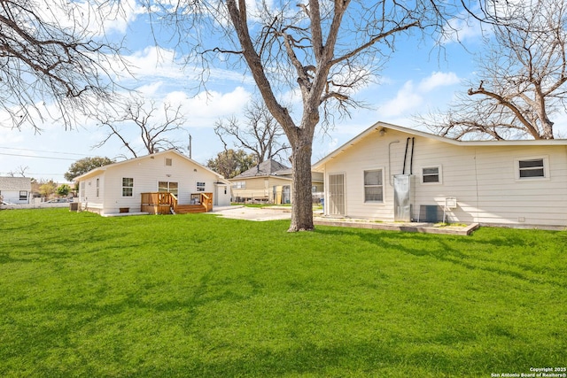 back of house with a lawn and a deck