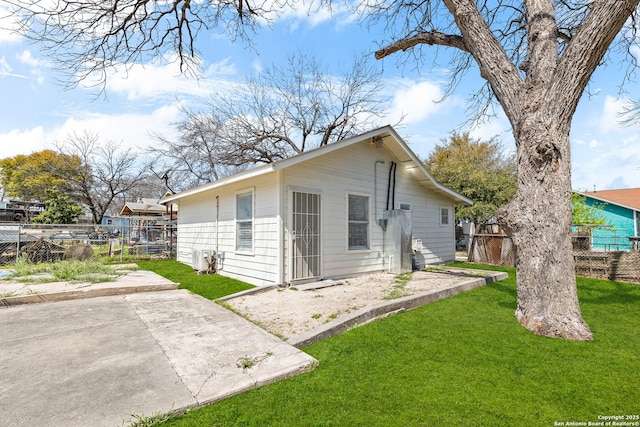 view of property exterior with a yard and fence