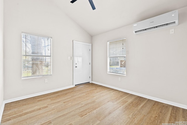 empty room featuring a wall unit AC, wood finished floors, and baseboards