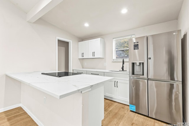 kitchen with stainless steel refrigerator with ice dispenser, a sink, white cabinetry, light wood finished floors, and black electric cooktop