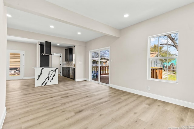 unfurnished living room with beamed ceiling, recessed lighting, light wood-style floors, and baseboards