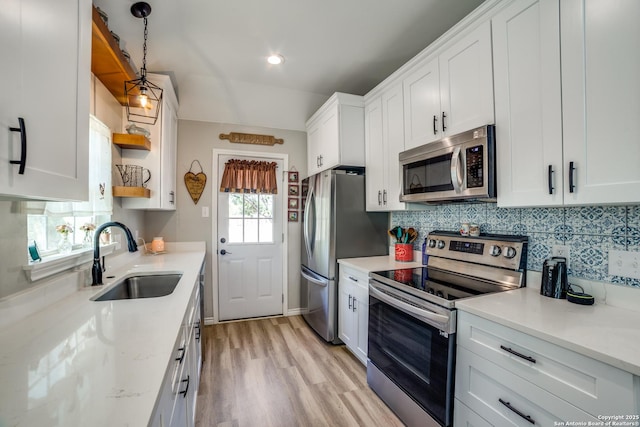 kitchen featuring open shelves, a sink, stainless steel appliances, white cabinetry, and backsplash