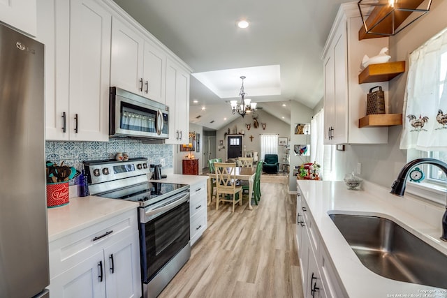 kitchen featuring a sink, appliances with stainless steel finishes, light wood-style floors, white cabinetry, and open shelves