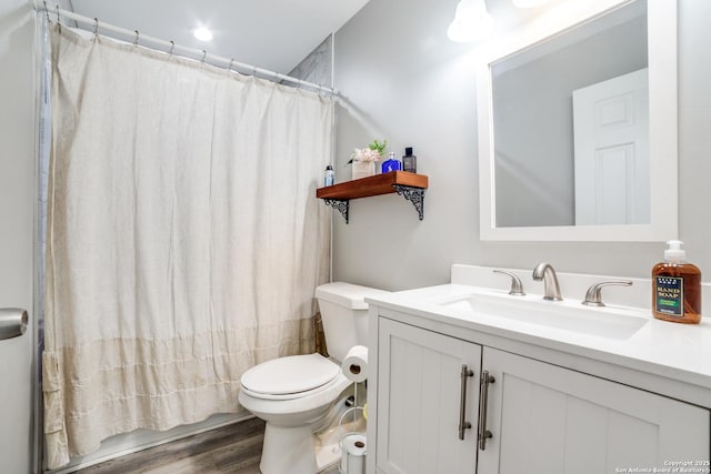 full bathroom featuring toilet, vanity, and wood finished floors