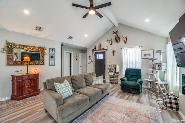 living area featuring visible vents, beam ceiling, wood finished floors, and a ceiling fan