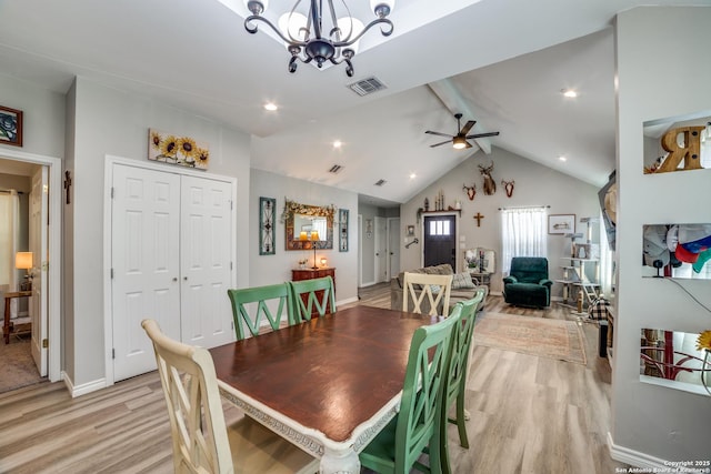 dining area with lofted ceiling with beams, ceiling fan with notable chandelier, visible vents, and light wood finished floors