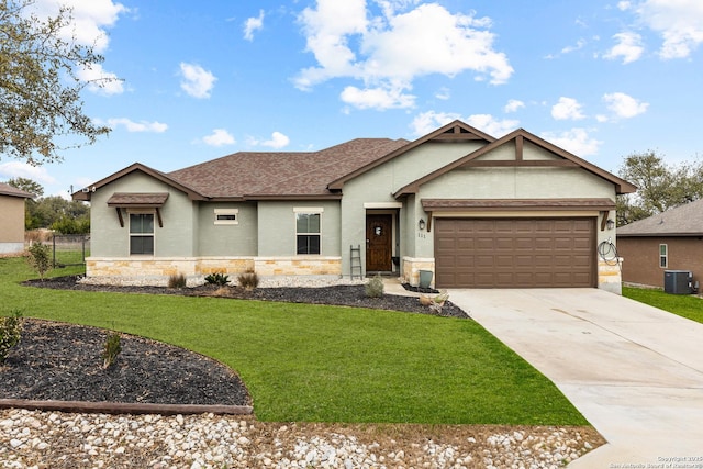 single story home with a front lawn, stone siding, central AC, concrete driveway, and an attached garage