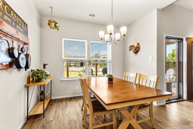 dining space featuring light wood-type flooring, visible vents, baseboards, and an inviting chandelier