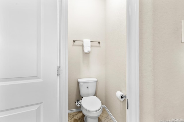 bathroom with tile patterned floors, toilet, and baseboards