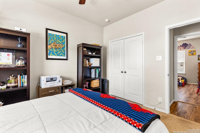 bedroom with wood finished floors, baseboards, a closet, and ceiling fan