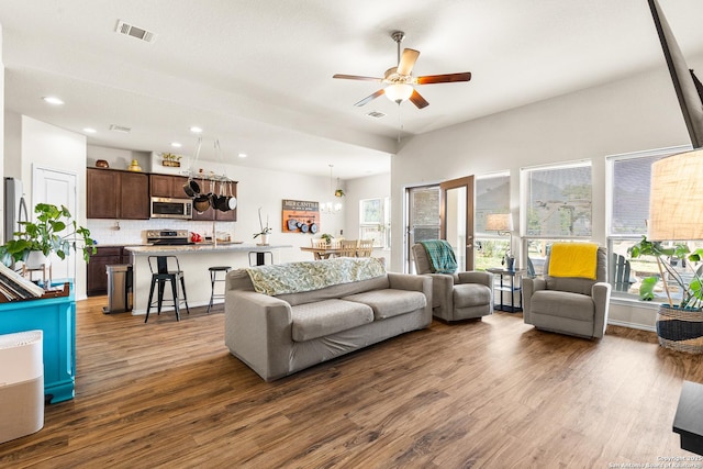 living area featuring plenty of natural light, wood finished floors, visible vents, and ceiling fan