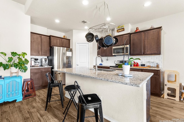 kitchen with visible vents, appliances with stainless steel finishes, light wood-type flooring, and a sink