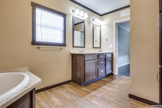 full bath with crown molding, double vanity, wood finished floors, and visible vents