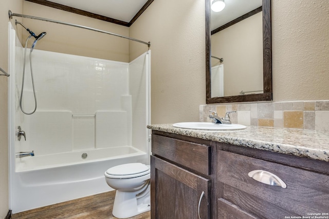 full bathroom featuring toilet, ornamental molding, wood finished floors, tub / shower combination, and vanity