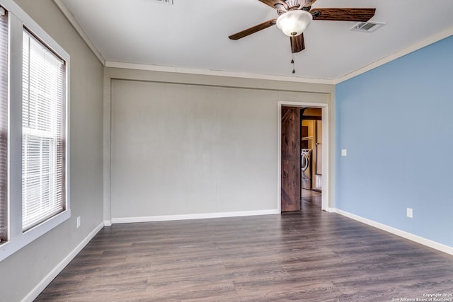 unfurnished room with visible vents, washer / clothes dryer, wood finished floors, crown molding, and baseboards