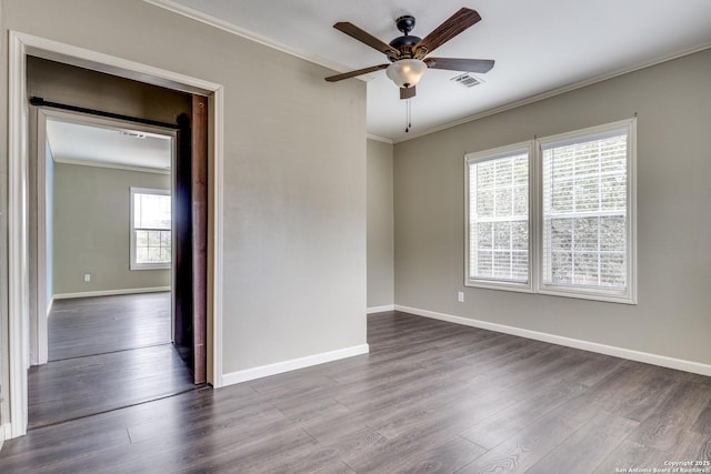 spare room with crown molding, dark wood-style floors, and baseboards