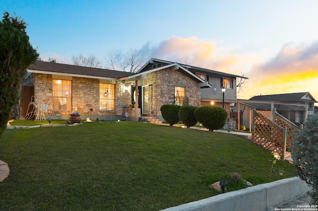 view of front of home featuring stone siding and a lawn