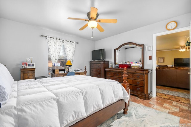 bedroom with stone finish flooring and a ceiling fan