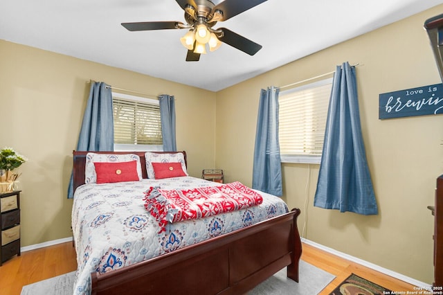 bedroom featuring ceiling fan, baseboards, and wood finished floors