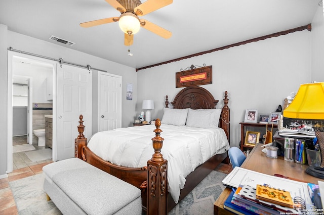 bedroom with visible vents, light tile patterned flooring, a closet, a barn door, and connected bathroom