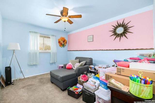 living area featuring carpet, baseboards, and ceiling fan