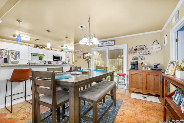 dining room with an inviting chandelier and ornamental molding