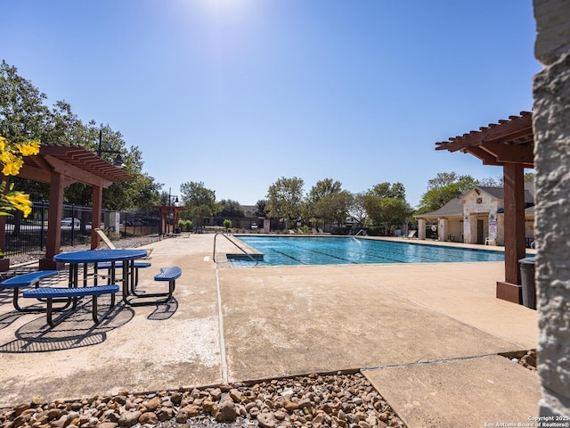 pool with a patio, fence, and a pergola