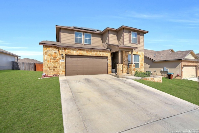 prairie-style house with solar panels, an attached garage, a front lawn, fence, and driveway